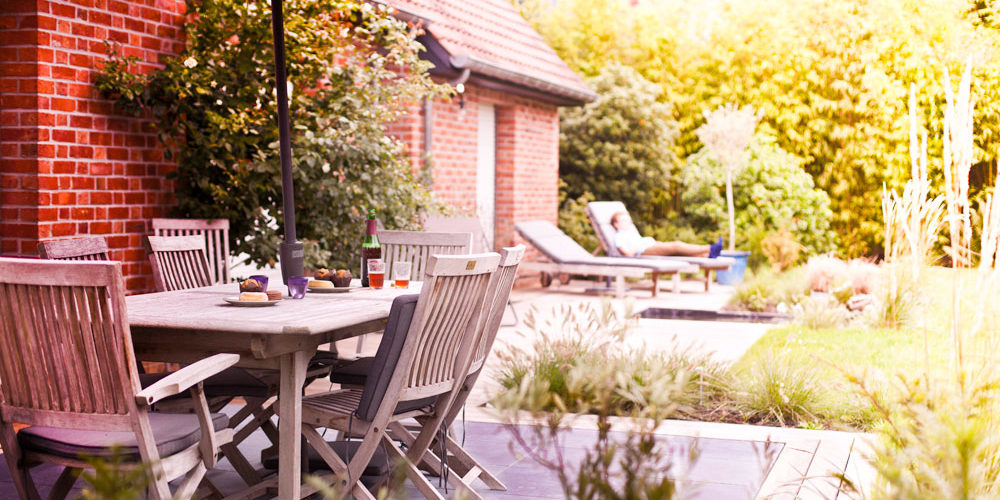Une terrasse idéale pour le repos et les repas entre amis. Elle est composée de pierre bleue mêlée à de l'ipé. Elle est agrémentée par des plantations de fleurs, de graminées et d'un petit bassin.
